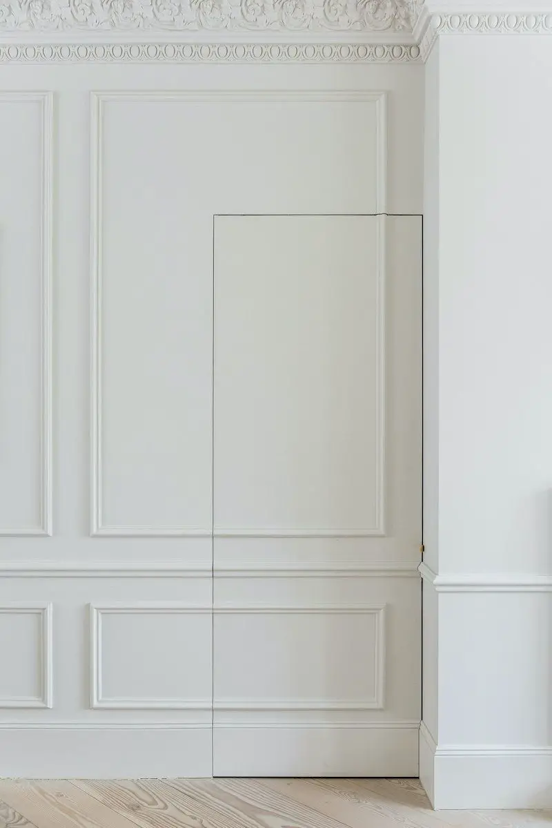 Use Molding or Woodworking to hide the Door in the room