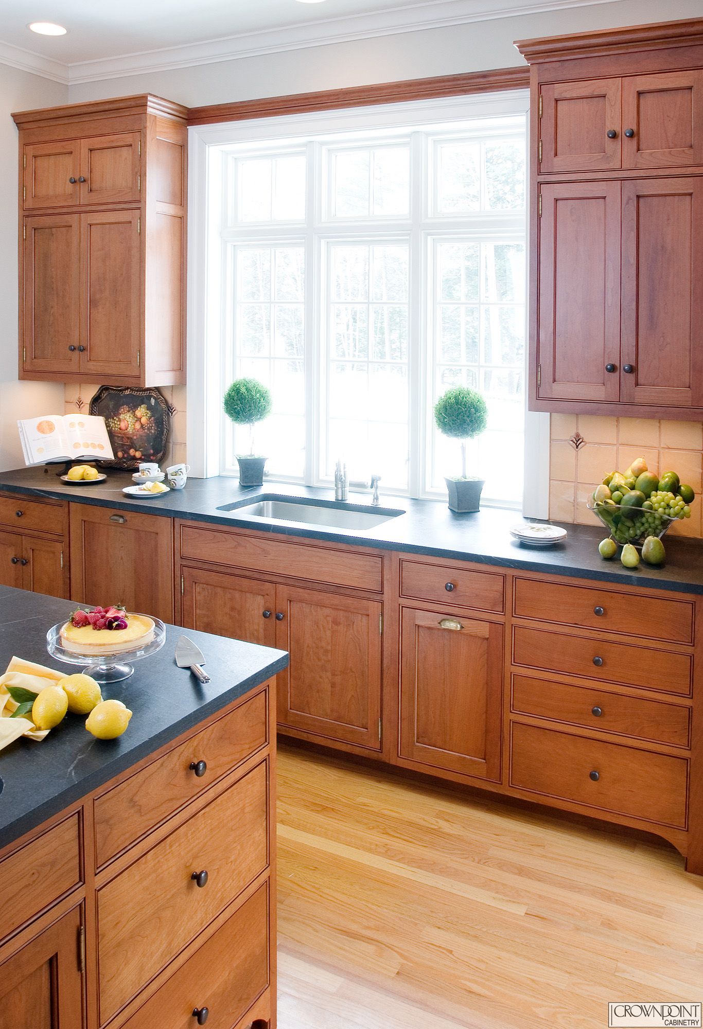 Use window coverings that let in natural light during the day and brighten your dark cherry cabinets.