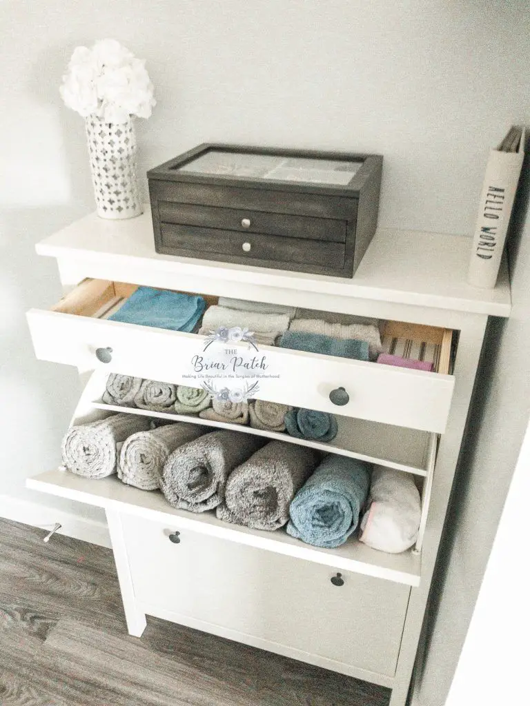 Utilize shelves to store towels in a corridor, bathroom, or bedroom, and use baskets to organize them further.