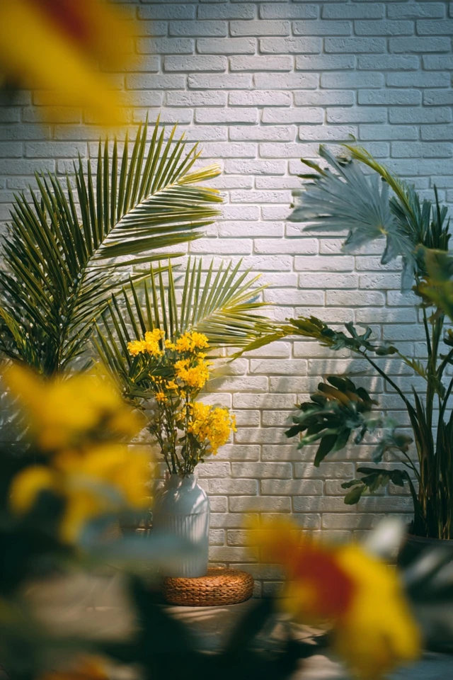 Bedroom brick wall styled with art, plants and lamps for added texture